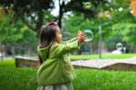 little girl catching bubbles