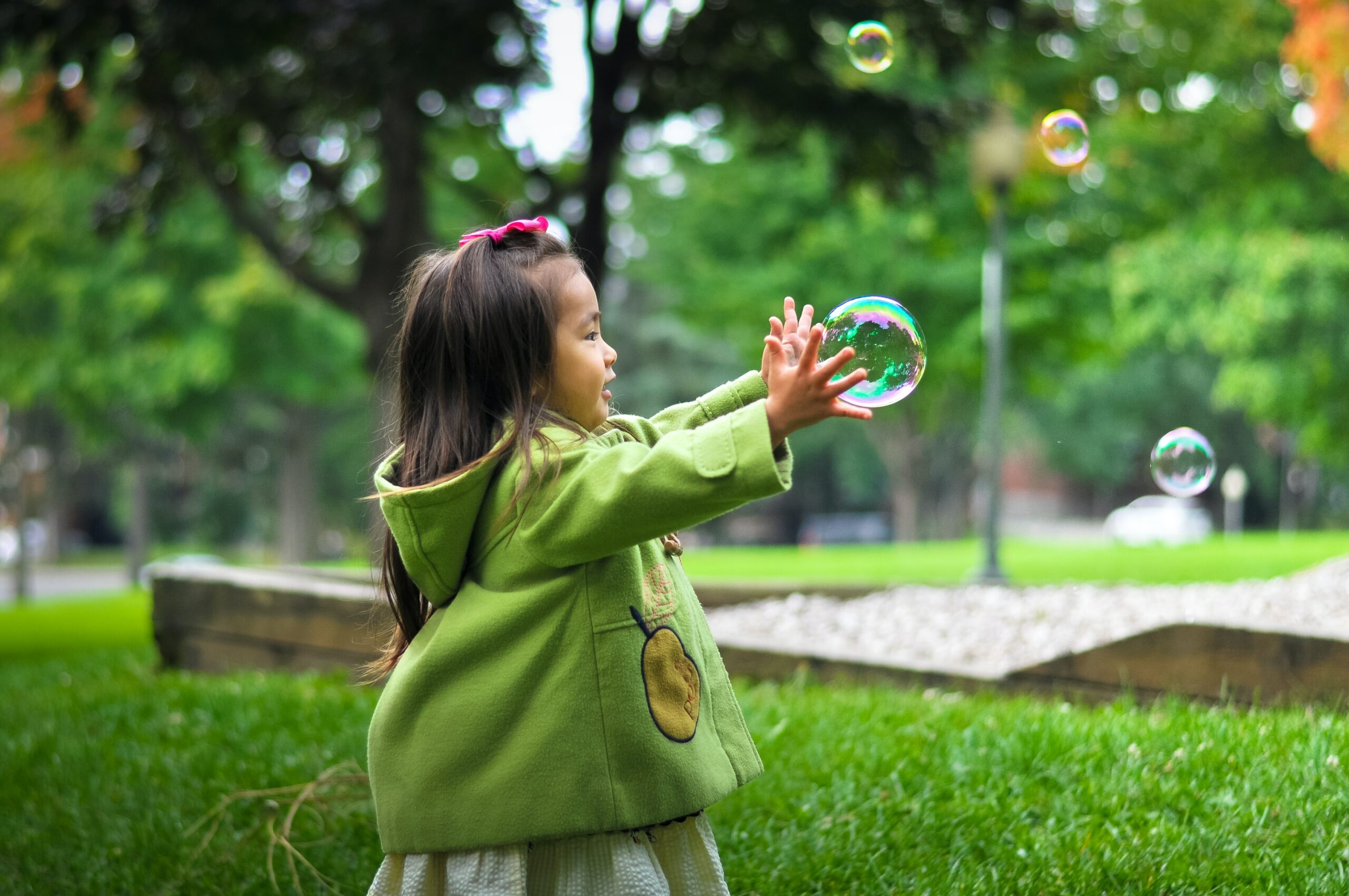 little girl catching bubbles