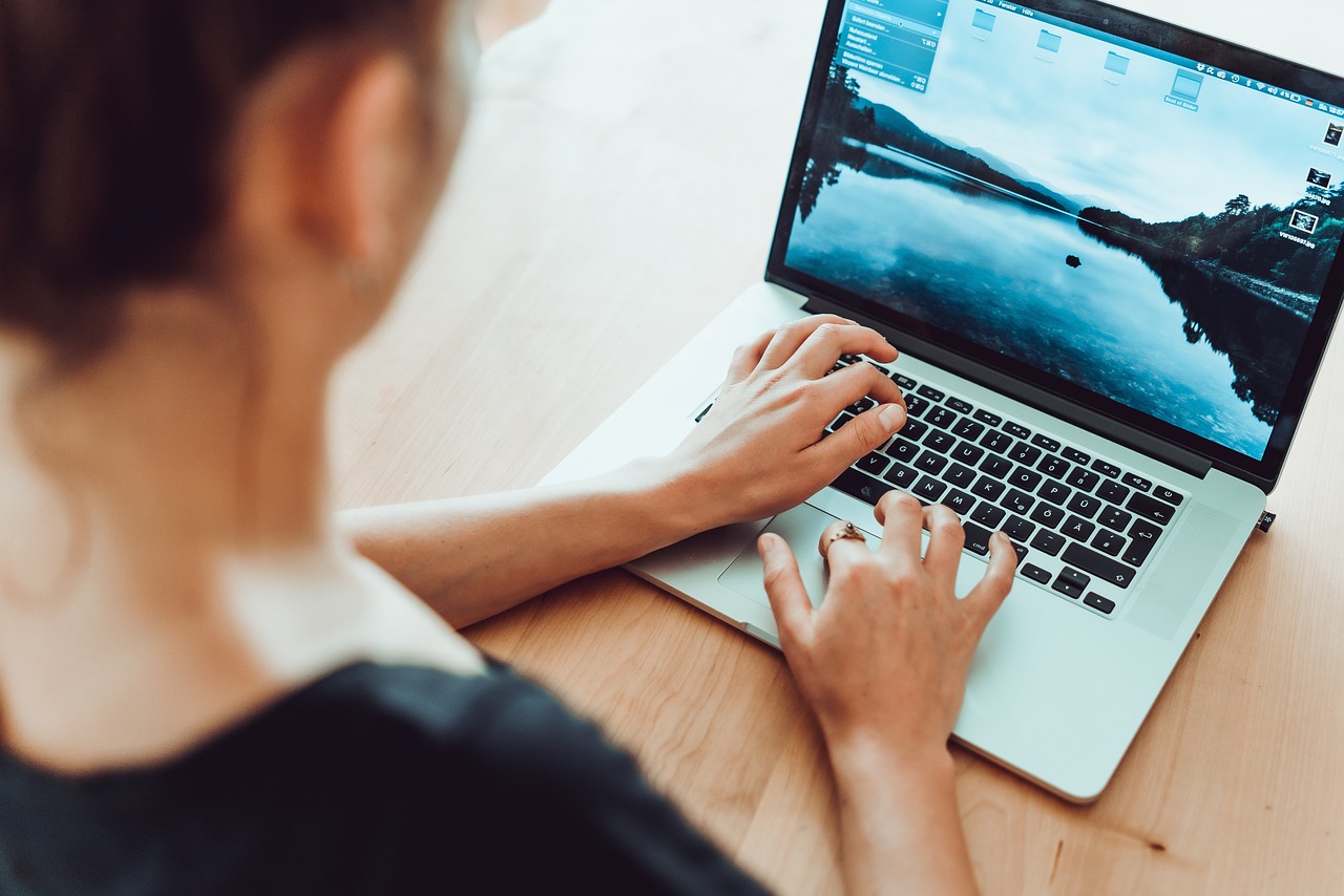 Woman working on an open laptop: side hustle mistakes