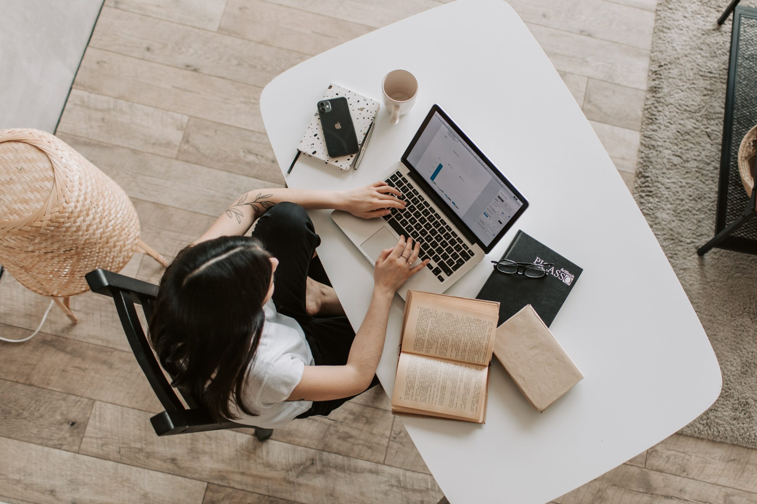 Top view of a woman typing on her laptop at her desk: work from home inspiration