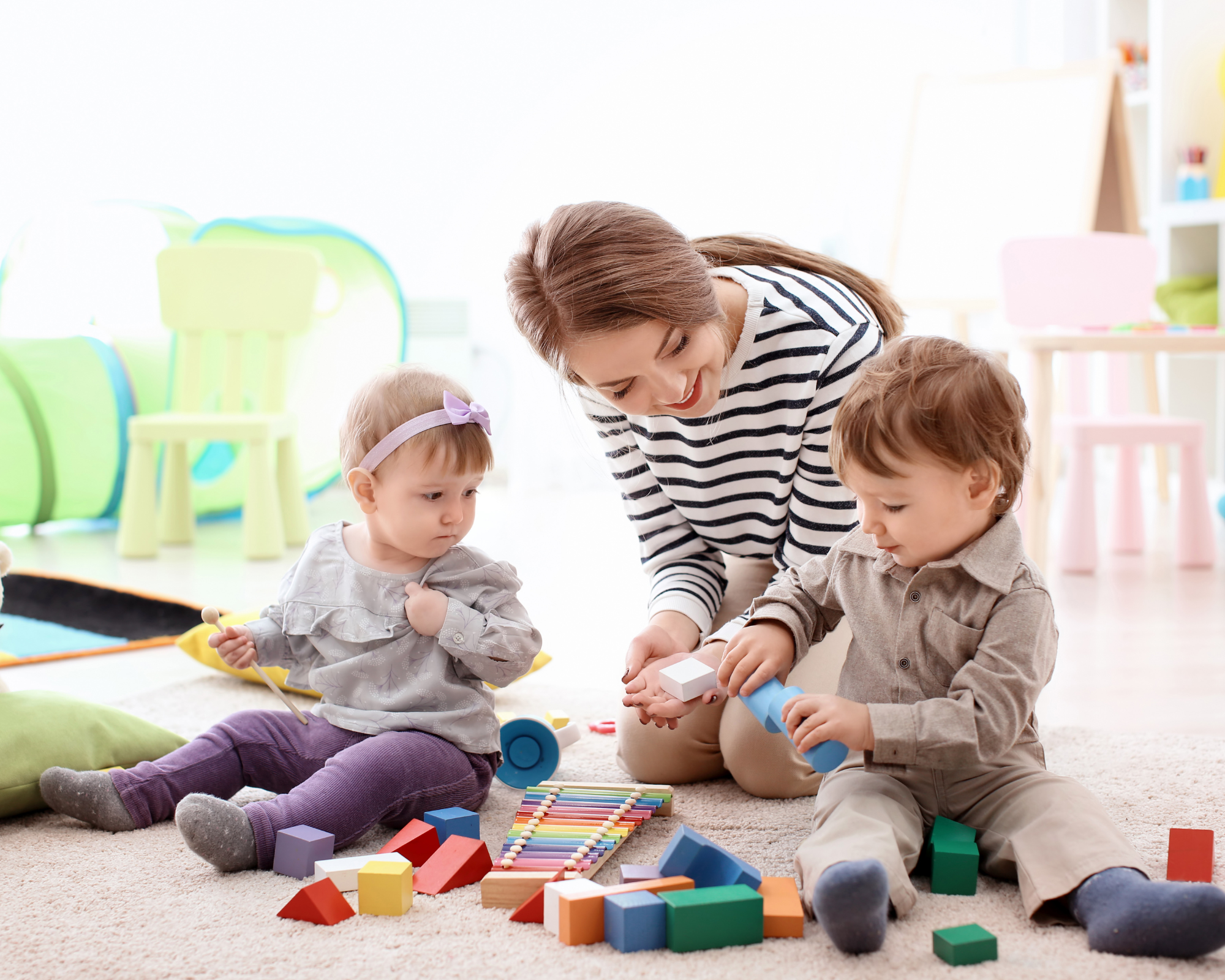 babysitter playing on the floor with two children: reasons to hire a babysitter