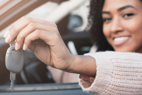 Woman in car with key in hand: Choose The Perfect Car As A New Mother