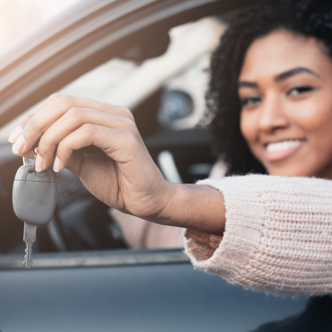 Woman in car with key in hand: Choose The Perfect Car As A New Mother