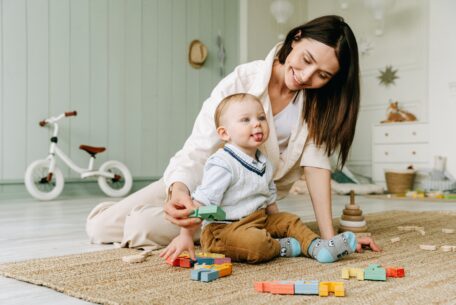 Mom playing with child on the ground with blocks: safety with kids