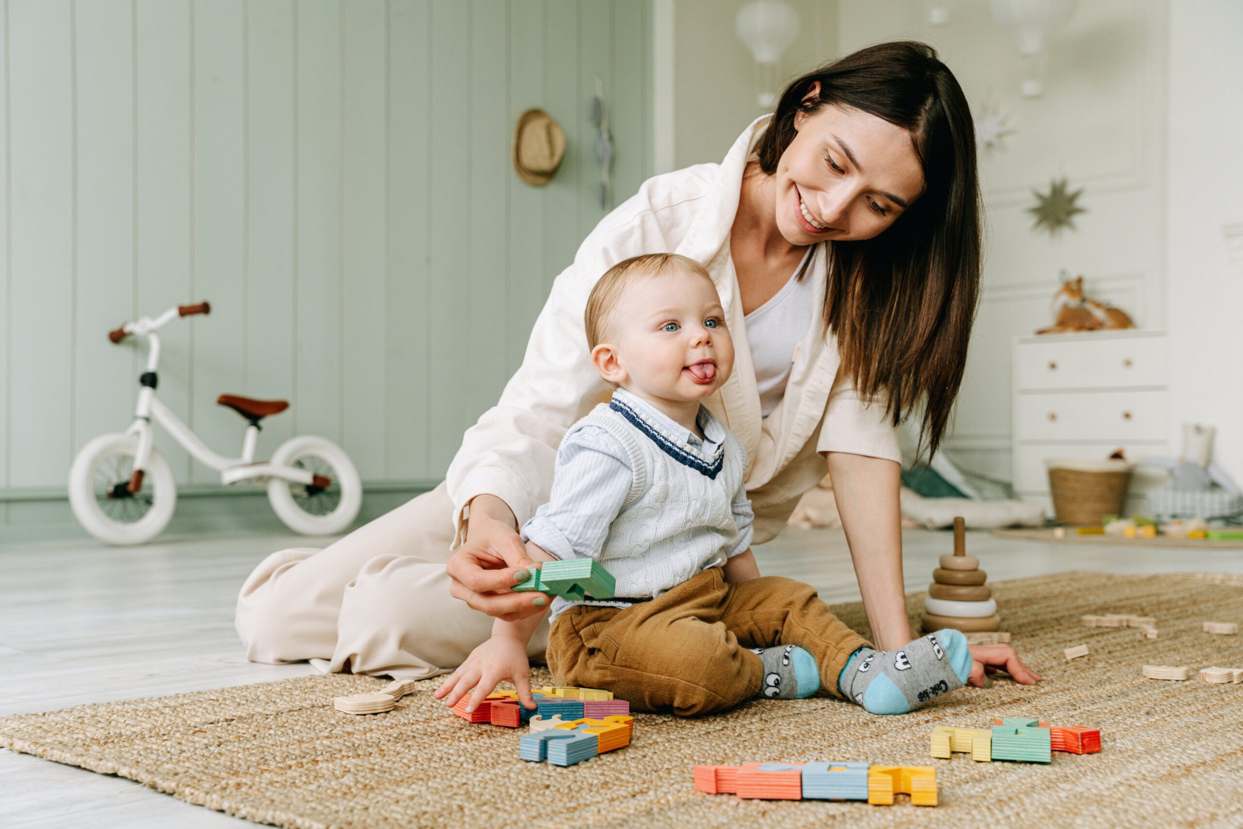 Mom playing with child on the ground with blocks: safety with kids