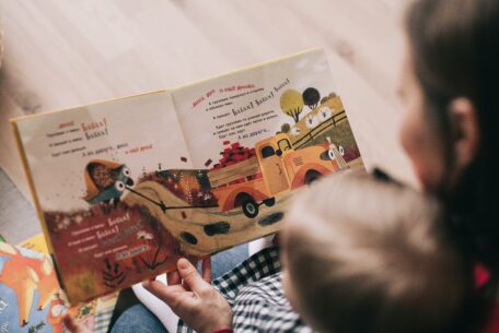 Woman reading book to toddler: Write A Children’s Book
