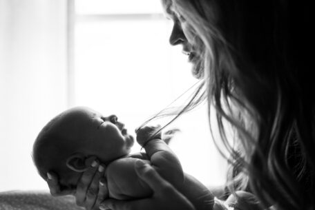 Black and white image of mother holding infant: manage mental health as a mom