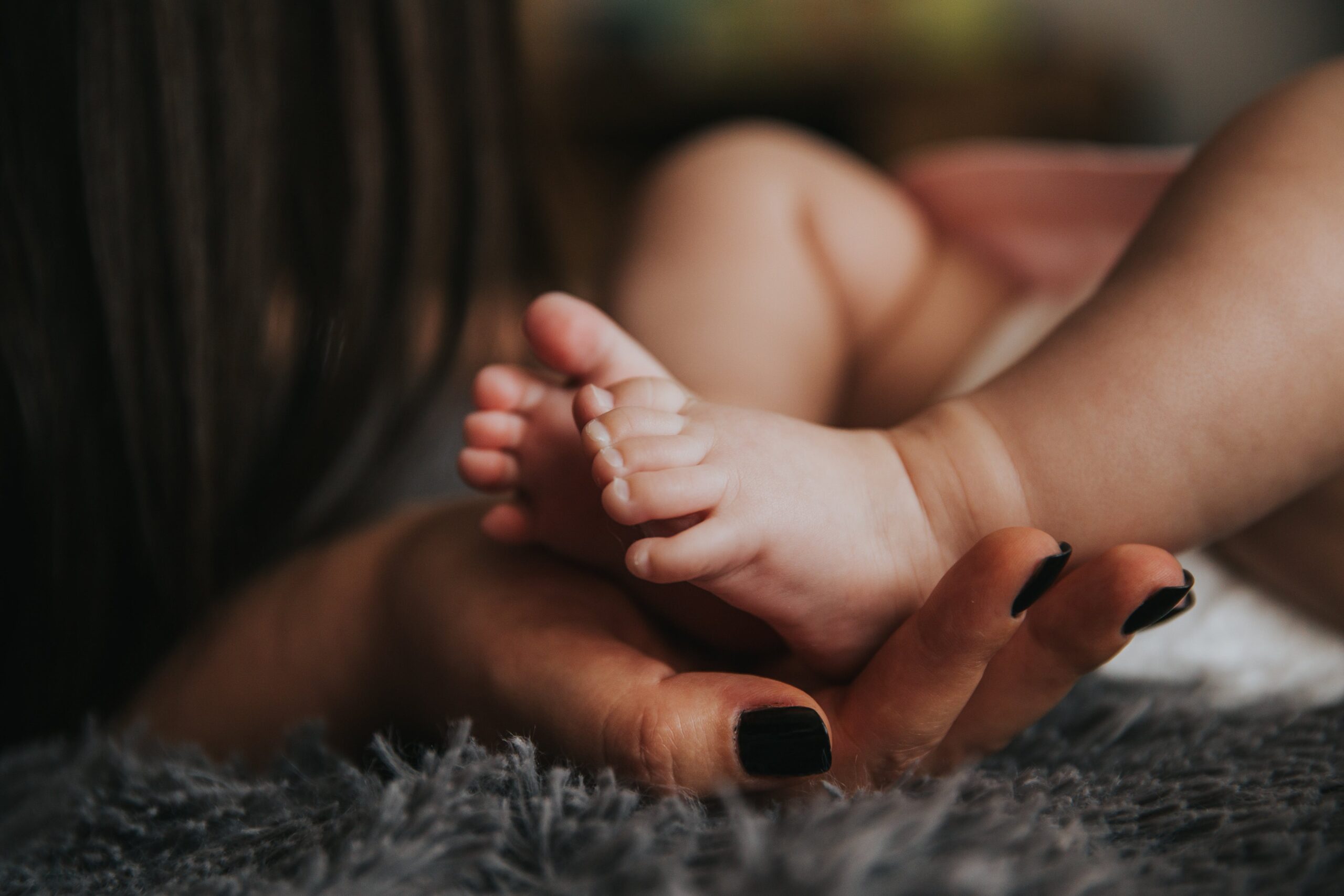 Woman holding baby's feet: losing yourself motherhood