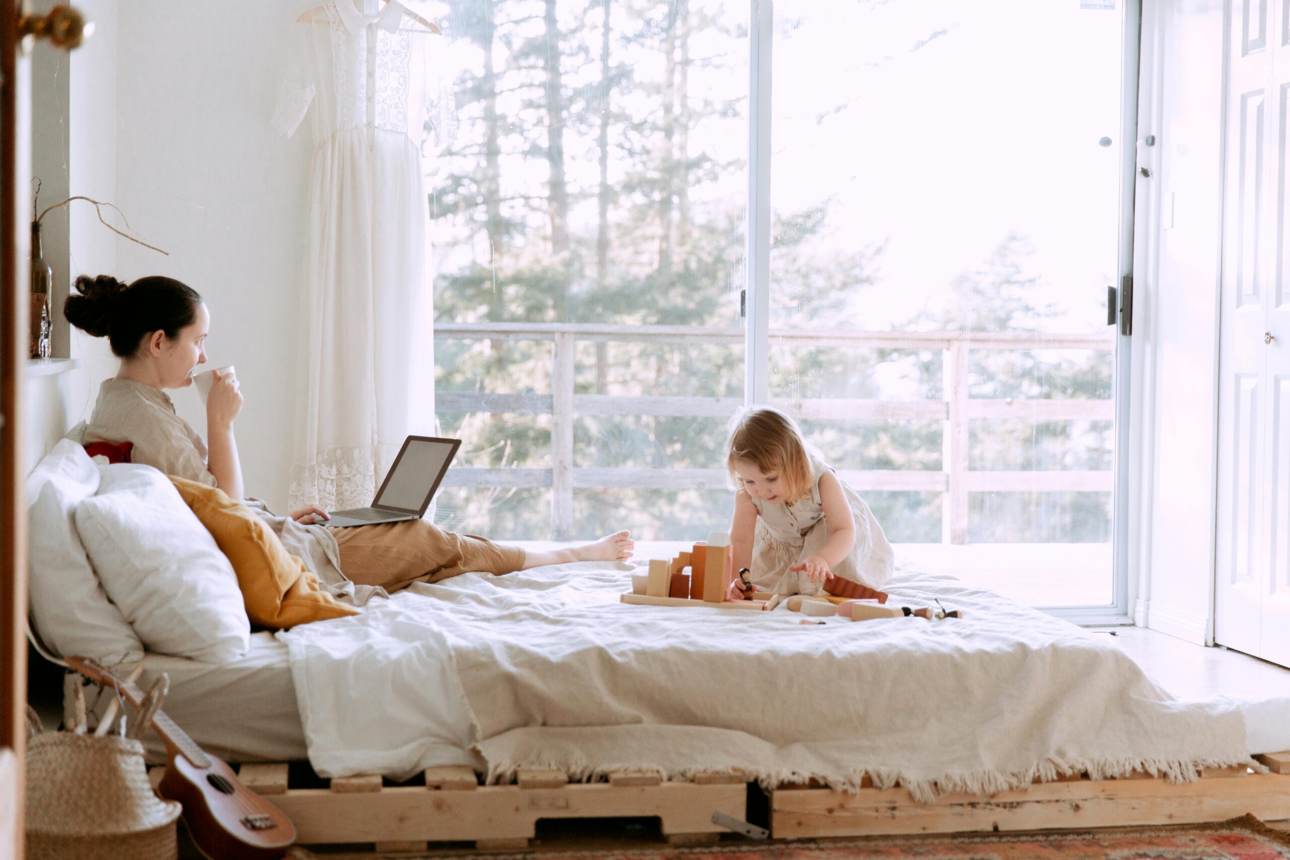 woman sitting on bed with child